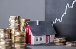 House with stacked coins and a rising financial chart representing home affordability and mortgage qualification in Canada.