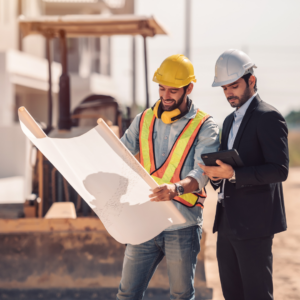 Construction professionals reviewing building plans at a development site